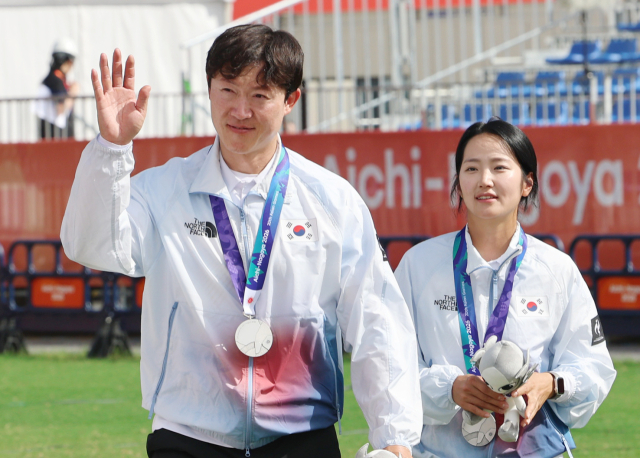 2026 아이치·나고야 아시안게임 양궁 컴파운드 혼성 단체전 은메달리스트 최용희(왼쪽)와 박정윤이 30일 일본 아이치현 오카자키 중앙종합공원 다목적광장에서 열린 시상식을 마치고 퇴장하며 관중석을 향해 인사하고 있다. 연합뉴스