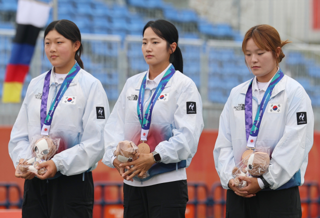 양궁 컴파운드 여자 단체팀 강연서, 박정윤, 박예린(왼쪽부터)이 30일 일본 아이치현 오카자키 중앙종합공원 다목적광장에서 열린 2026 아이치·나고야 아시안게임 양궁 컴파운드 여자 단체전에서 동메달을 획득한 후 시상대에 올랐다. 연합뉴스