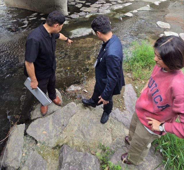 김효정 부산시의회 교육위원장이 현장 관계자들과 부산 북구 덕천천을 살펴보고 있다. [사진=부산시의회]