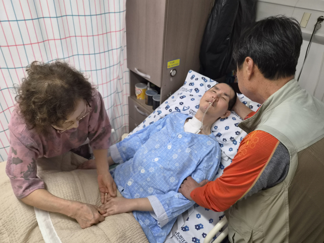 지난달 29일 경산의 한 병원에서 고인성(가명·66) 씨 부부가 재하(가명·39) 씨를 돌보고 있는 모습. 윤정훈 기자