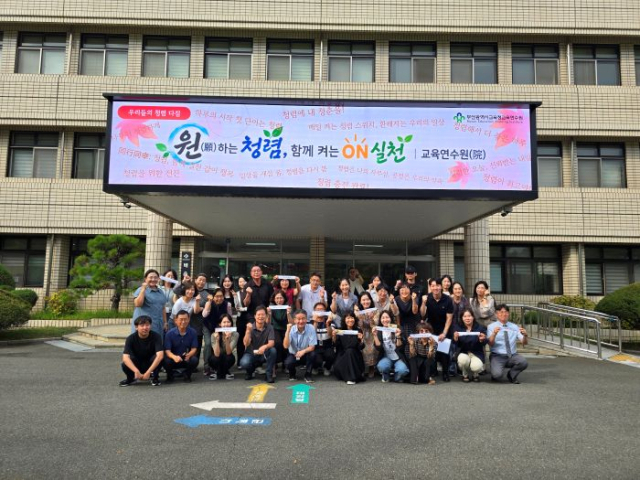 부산교육연수원 직원들이 본관 앞에서 청렴 소품을 들고 기념촬영을 하고 있다. [사진=부산교육청]