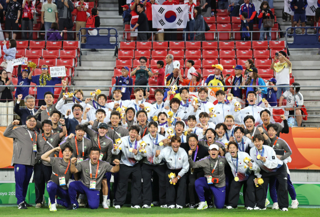 10월 3일 일본 아이치현 도요타 스타디움에서 열린 2026 아이치·나고야 아시안게임 남자 축구 시상식에서 금메달을 획득한 한국 대표팀 선수들이 이민성 감독을 비롯한 코칭 스태프들과 기념촬영을 하고 있다. 연합뉴스