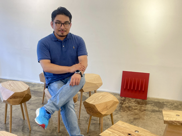 오명석 작가가 전시장에 놓인 자신의 아트퍼니처 위에 앉아 있다. 이연정 기자