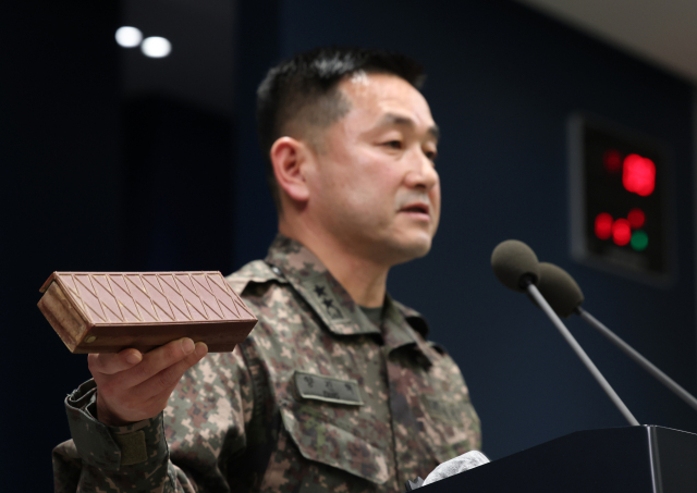 양진혁 합동참모본부 작전부장이 5일 서울 용산구 국방부에서 비무장지대(DMZ) 지뢰 폭발 관련해 합동 현장조사 TF 최종 조사 결과를 설명하고 있다. 손에 든 것은 수지 반보병지뢰. 갈색 사각형 형태 표면 격자형 무늬 지뢰다. 연합뉴스