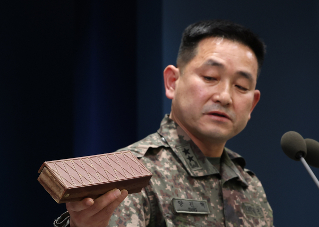 양진혁 합동참모본부 작전부장이 5일 서울 용산구 국방부에서 열린 비무장지대(DMZ) 지뢰 폭발 관련 합동 현장조사 TF 최종 조사 결과 발표 브리핑에서 이전에 수거했던 수지 반보병지뢰를 들어보이고 있다. 연합뉴스