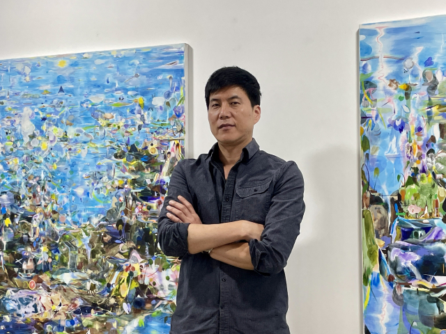이대천 작가가 자신의 작품 앞에서 포즈를 취하고 있다. 이연정 기자