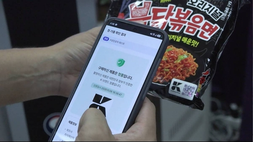 지식재산처가 도입한 K브랜드 국가인증상표를 소비자가 휴대전화 카메라로 스캔해 정품 여부를 확인하고 있다. 연합뉴스