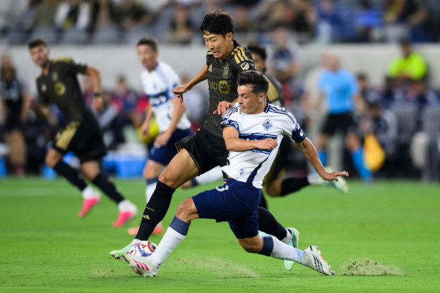 LAFC의 손흥민이 11일 미국 LA에서 열린 MLS 밴쿠버 화이트캡스와의 홈 경기 도중 상대 선수와 공을 다투고 있다. AP 연합뉴스