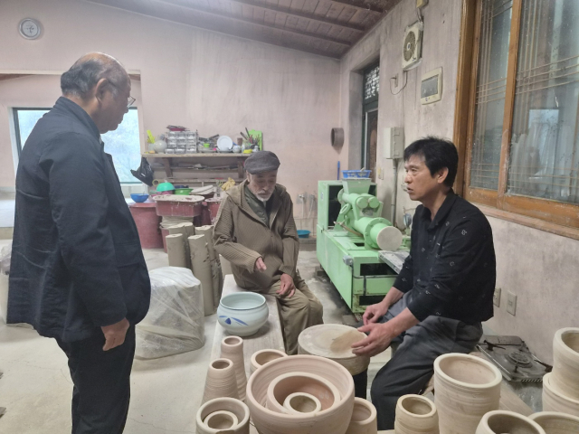 조선요 김영식 경북 무형문화재 사기장(사진 오른쪽)이 나카자토 다카시 선생(중앙)에게 발물레 돌리는 것에 대해 설명을 하고 있다. 전병용 기자