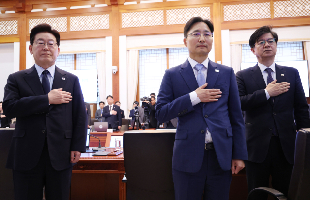 이재명 대통령이 15일 청와대에서 열린 수석보좌관회의에서 국기에 경례하고 있다. 오른쪽은 임광현 신임 비서실장과 성기홍 홍보소통수석. 연합뉴스