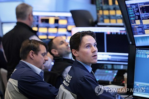 15일(현지시간) 미국 뉴욕증권거래소(NYSE) 앞에서 트레이더들이 시황을 확인하고 있다. 연합뉴스