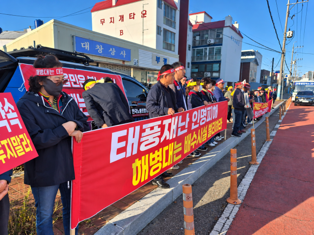 15일 오전 경북 포항시 남구 오천읍 해병대 제1사단 정문 앞에서 주민들이 배수시설 설치와 부대 이전 약속 이행을 촉구하는 현수막을 들고 집회를 벌이고 있다. 서민재 기자