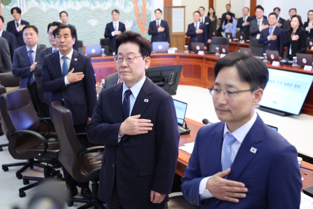 이재명 대통령이 15일 청와대에서 열린 수석보좌관회의에서 국기에 경례하고 있다. 연합뉴스