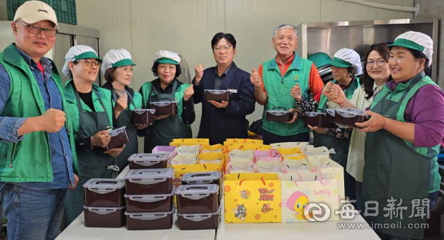 율곡면 새마을협의회·부녀회 회원들이 정성껏 준비한 사랑의 고추장을 용기에 담아 들어 보이고 있다. 합천군 제공