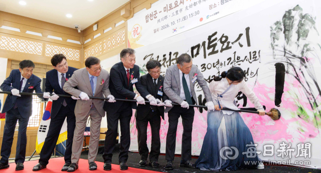 합천군과 미토요시 관계자들이 17일 자매결연 30주년 기념식에서 대형 붓을 함께 잡고 휘호 퍼포먼스를 하고 있다. 합천군 제공