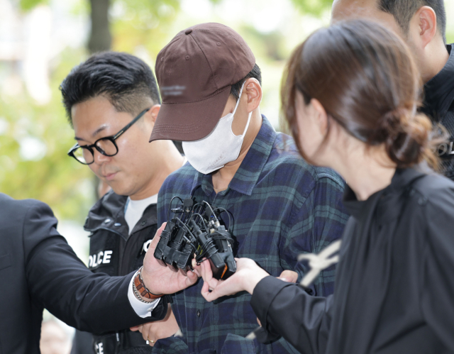 이혼소송 중 장모 살해 및 아내를 납치한 20대 중반 남성 A씨가 13일 서울 송파구 서울동부지방법원에서 열린 구속 전 피의자 심문(영장실질심사)에 출석하고 있다. 연합뉴스