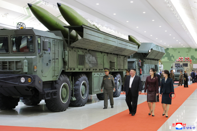 김정은 북한 국무위원장이 지난 11일 개관한 제2경제위원회 국방혁명박물관에서 딸 주애, 담뱃갑과 성냥갑으로 보이는 물건을 손에 쥔 리설주 여사와 함께 미사일을 실은 발사차량 앞을 걷고 있다. [국내에서만 사용가능. 재배포 금지. For Use Only in the Republic of Korea. No Redistribution] 연합뉴스