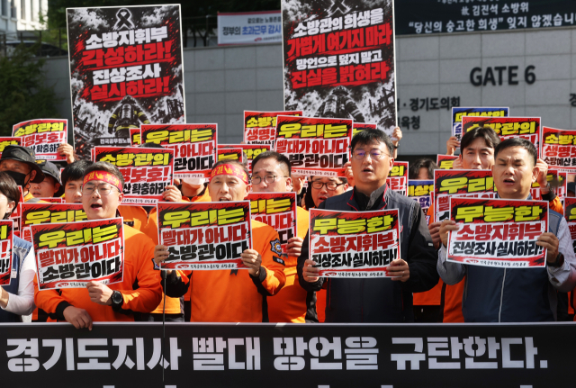 20일 경기도 수원시 경기도청 앞에서 열린 고 김진석 소방위 순직 사고 진상규명 촉구 기자회견에서 전국공무원노동조합 소방본부 소방관들이 구호를 외치고 있다. 연합뉴스
