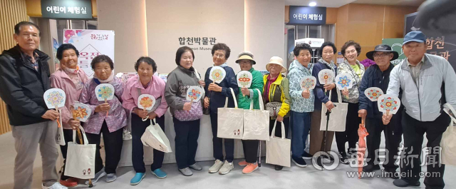 합천박물관을 찾은 대병면 성인문해교실 학습자들이 직접 색칠한 부채를 들어 보이고 있다. 합천군 제공