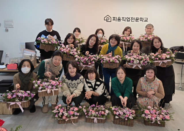 김숙경씨의 꽂꽂이 교실 수강생들이 각자 완성한 꽃꽃이 작품을 들고 기념촬영을 하고 있다.