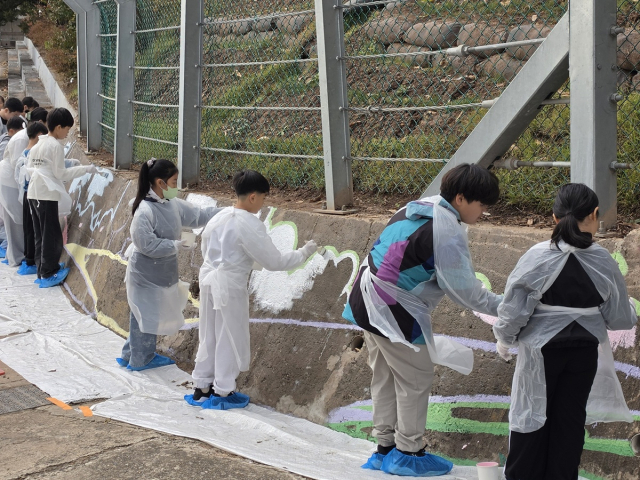 경북 청송군 안덕초 전교생과 교직원이 함께 지난 5일부터 23일까지 3주간 학교 서편 옹벽에 길이 57m 규모의 벽화를 조성했다. 청송교육지원청 제공