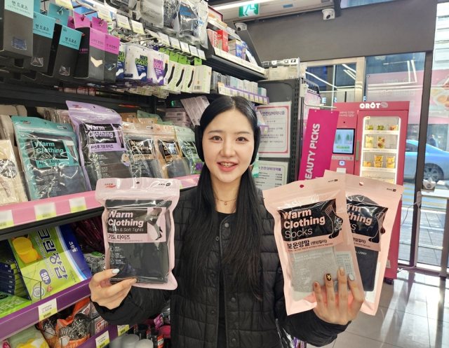 CU가 겨울철을 맞아 방한의류 상품군을 확대하고 있는 가운데, 한 CU 매장에서 모델이 기모 타이즈와 보온양말 등 동절기 상품을 소개하고 있다. CU 제공