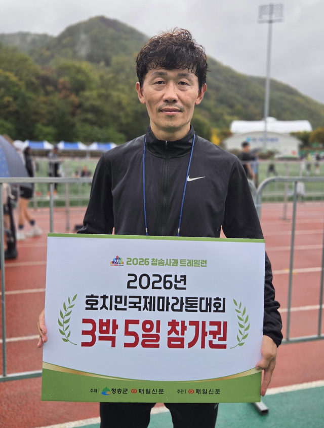 2026 청송사과트레일런 하프 코스 남자 1위를 달성한 구미사랑마라톤클럽 정운산(48) 씨가 1등 부상으로 받은 호치민국제마라톤대회 3박 5일 참여권을 들어 보이며 기념 촬영하고 있다. 김영진 기자