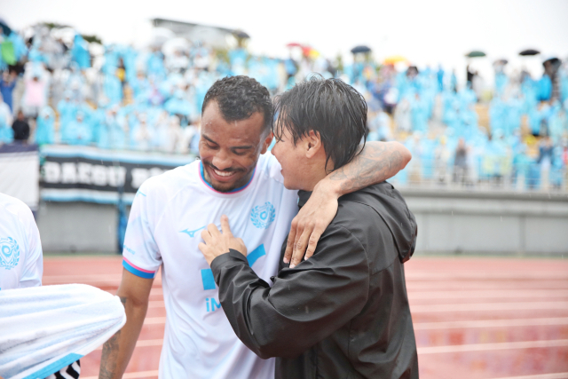 프로축구 K리그2 대구FC 최성용 감독(오른쪽)이 24일 순천팔마종합운동장에서 열린 전남 드래곤즈와의 경기에서 10-10(한 시즌 10골 10도움)을 달성한 세라핌을 축하해주고 있다. 대구FC 제공