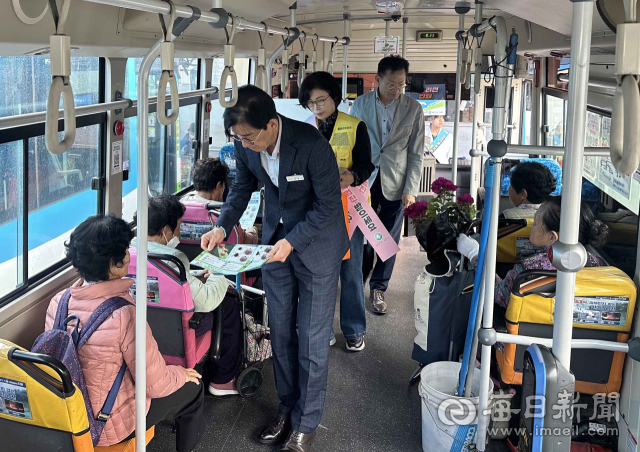 캠페인 참가자들이 23일 버스에 올라 승객들에게 감염병 예방 홍보 리플릿을 나눠주고 있다. 합천군 제공