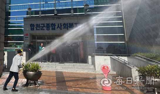 지난 22일 합천군종합사회복지관 합동 소방훈련에서 소방호스로 건물 입구 쪽에 물을 뿌리는 방수 훈련이 진행되고 있다. 합천군 제공