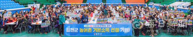 25일 합천체육관에 모인 800여 명의 재외합천향우와 행사 참석자들이 농어촌 기본소득 시범사업 선정을 바라는 문구가 적힌 피켓을 들고 합천군의 사업 유치에 힘을 보태고 있다. 합천군 제공