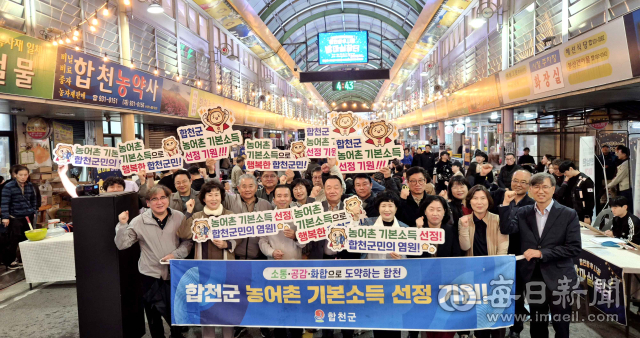 합천군 관계자와 주민들이 왕후시장 밤마실장터에서 현수막과 피켓을 들고 농어촌 기본소득 시범사업 공모 선정을 기원하고 있다. 합천군 제공
