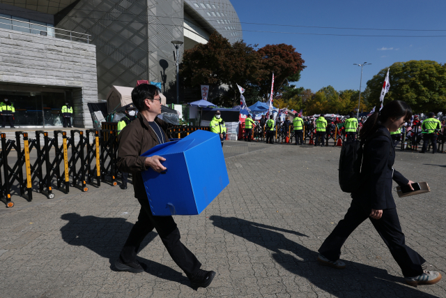 6·3 지방선거 투표용지 부족 사태 등을 수사하는 이태한 선거관리위원회 특별검사팀이 27일 서울 송파구 올림픽공원 핸드볼경기장을 압수수색했다. 특검 관계자들이 이날 상자를 들고 송파지역 개표소로 쓰인 핸드볼경기장을 나서고 있다. 연합뉴스